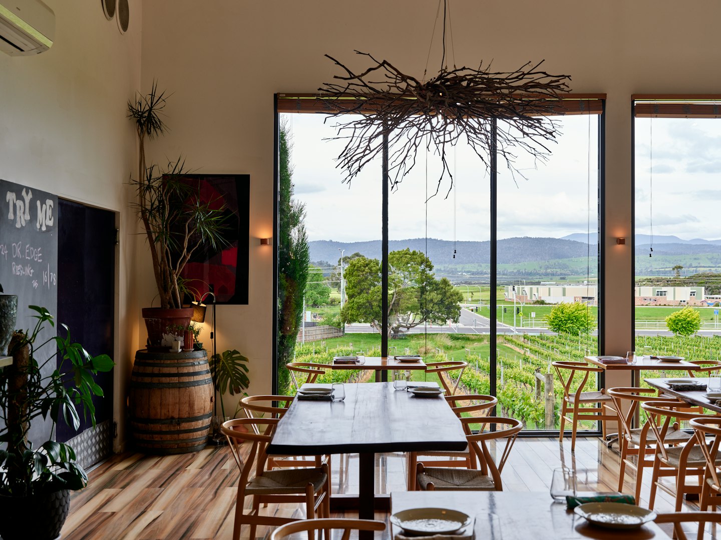 Comedor de restaurante con vista a un viñedo y barril de vino.