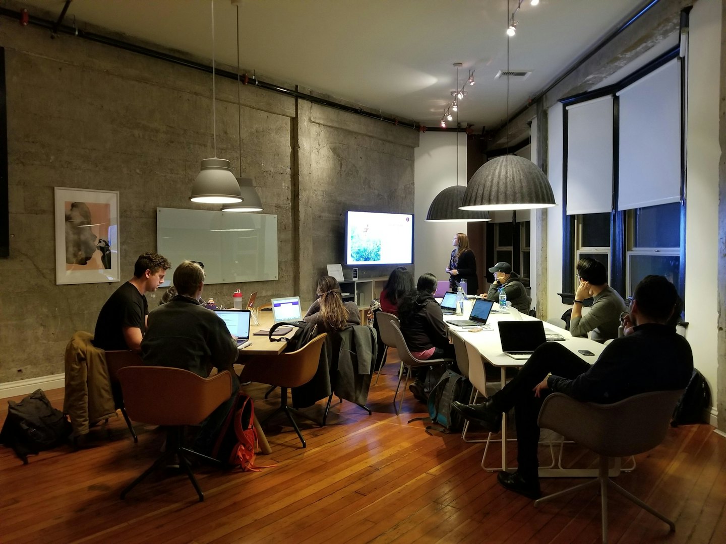 Profesionales colaboran alrededor de mesas en una sala de reuniones moderna.
