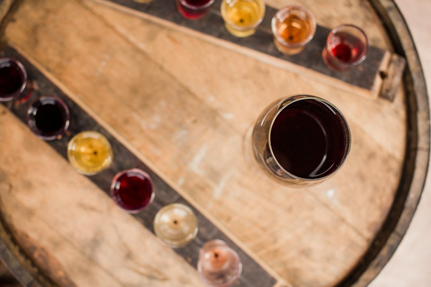 Copas de cata de vino tinto sobre la tapa de un barril de vino.